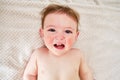 Crying screaming toddler baby boy is lying on the bed. Unhappy child c Royalty Free Stock Photo