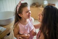 Crying small girl with mother indoors, loosing baby tooth.