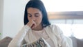 Crying teenage female sitting on couch upset of heartbreak