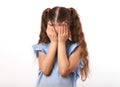 Crying unhappy kid girl closed the hands the face on white background with empty copy space. Closeup portrait