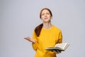 Crying unhappy young woman with closed eyes college student wearing yellow sweater holding book