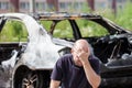 Crying upset man at arson fire burnt car vehicle junk