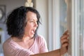 Crying woman standing at a window