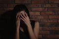 Crying young woman near wall. Domestic violence concept Royalty Free Stock Photo