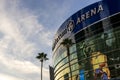 Crypto.com Arena at sunset with lush green palm trees, blue sky and clouds in Los Angeles California