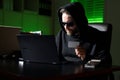 Crypto currency hacking. Hacking hunting for crypto currency. Cryptocurrency hack concept. Hacker in hoodie at night office Royalty Free Stock Photo