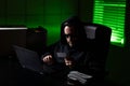 Crypto currency hacking. Hacking hunting for crypto currency. Cryptocurrency hack concept. Hacker in hoodie at night office Royalty Free Stock Photo
