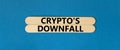 Crypto downfall symbol. Concept words Cryptos downfall on wooden stick. Beautiful blue table blue background. Business and crypto