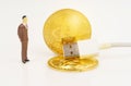 On a white surface are a bitcoin cord with USB and a miniature human figure. Royalty Free Stock Photo