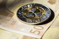 Cryptocurrency coins over euro banknotes; Ripple coin