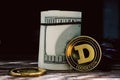 Cryptocurrency Dogecoin near a roll of dollars in a close-up on a dark background