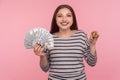 Cryptocurrency, electronic money. Portrait of happy woman in striped sweatshirt holding dollar bills and bitcoin