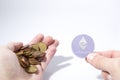 Cryptocurrency hand is holding euro coins and an etherum composition