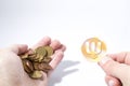 Cryptocurrency hand is holding euro coins and a primecoin compos