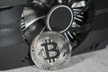 Cryptocurrency mining. Cryptocurrency mining. Bitcoin coin on a graphic card, video card for cryptocurrency mining. Royalty Free Stock Photo