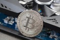 Cryptocurrency mining. Cryptocurrency mining. Bitcoin coin on a graphic card, video card for cryptocurrency mining. Royalty Free Stock Photo