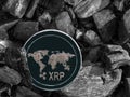 Cryptocurrency XRP coin lies on coal. Mining and Energy for mining.