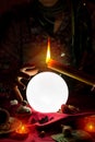 Crystal ball, candle and hand of gypsy fortune teller woman