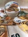 Crystal ball and large denomination euro banknotes. Royalty Free Stock Photo