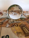 Crystal ball and large denomination euro banknotes. Royalty Free Stock Photo