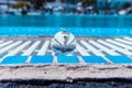 Crystal ball reflecting geometric white lines of the pool, abstract composition in white and blue in summer Royalty Free Stock Photo