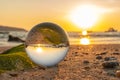 A crystal ball rests on the sandy pebbles of Kalim Beach.