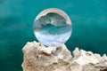 Crystal ball on the rock on the blue background