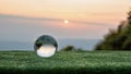 Crystal ball transparent in grass with beautiful sunset color
