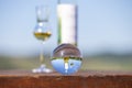 Crystal ball on wooden table with bottle and filled glass Royalty Free Stock Photo