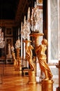 Crystal chandeliers and gold statues in Versailles