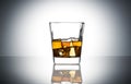 Crystal classic glass of whiskey with ice cubes on grey gradient background Royalty Free Stock Photo