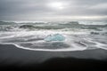 Crystal clear and blue ice chunks washes up on the black lava sand by the waves on diamond beach in Jokulsarlon glacier lagoon. Lo Royalty Free Stock Photo