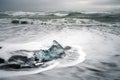 Crystal clear and blue ice chunks washes up on the black lava sand by the waves on diamond beach in Jokulsarlon glacier lagoon. Royalty Free Stock Photo