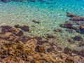 Crystal clear blue water - caustics effect - rocky shore