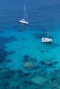 Crystal clear blue water under sailing boats, near Bonifacio, Corsica, vertical photo