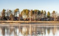 Crystal clear frozen lake in Northern Sweden - ice like big mirror. Many typical red swedish summer cabins stand in the forest on