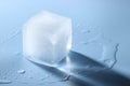 Crystal clear ice cube on light blue background, space for text Royalty Free Stock Photo