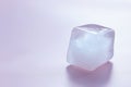 Crystal clear ice cube on light pink background, space for text Royalty Free Stock Photo