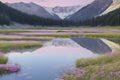 The lake reflects a pastel sky bathed in soft pinks and sapphires.