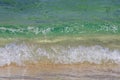 Crystal clear ocean water , white foam, wave on sandy beach. Royalty Free Stock Photo