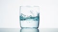 Crystal clear water with splashes in glass against a white background. Evokes a sense of purity and refreshment. Concept Royalty Free Stock Photo