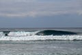 Crystal clear water splashes over surfer riding an epic barrel wave in spectacular Bali. Extreme sportsman surfing and