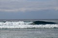 Crystal clear water splashes over surfer riding an epic barrel wave in spectacular Bali. Extreme sportsman surfing and