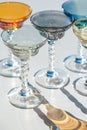 Crystal colorful stemware set with reflection over white background. Colourful elite set of empty alcohol liquor glasses