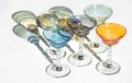 Crystal colorful stemware set with reflection over white background. Colourful elite set of empty alcohol liquor glasses