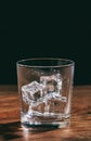 Crystal whiskey glass with ice cubes on a wooden table Royalty Free Stock Photo