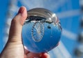 Crystal glass ball in male`s hand with a ferris wheel insid