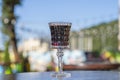 Crystal glass of cherry brandy liqueur with ripe berries on a table in a street cafe in Kiev, Ukraine Royalty Free Stock Photo