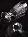 A crystal glass and a crystal ball lie on a table flooded with water