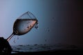 Crystal glass with water falling on a table while pouring water, with a dark background